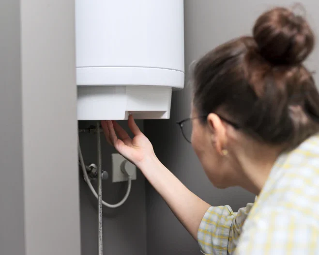 woman turning on the water heater